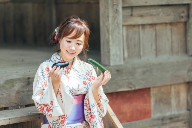 お盆のお供えを持った女性